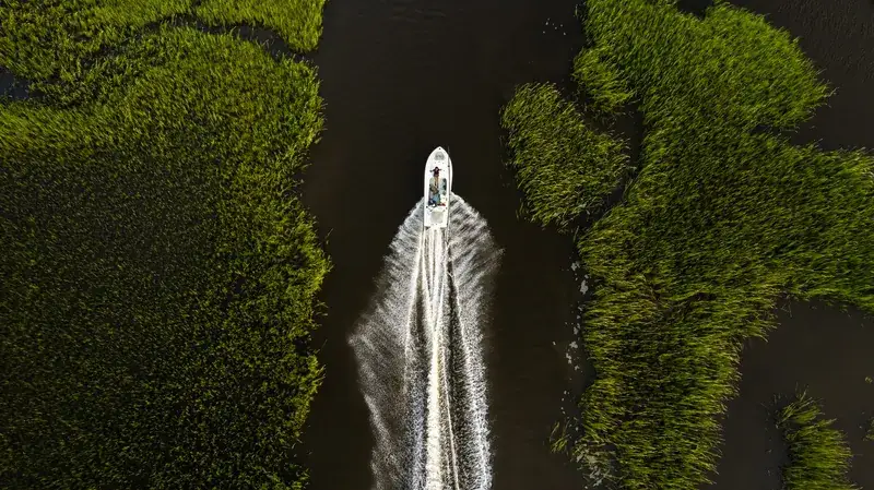 A center-console boat in a coastal marsh creek near St. Augustine